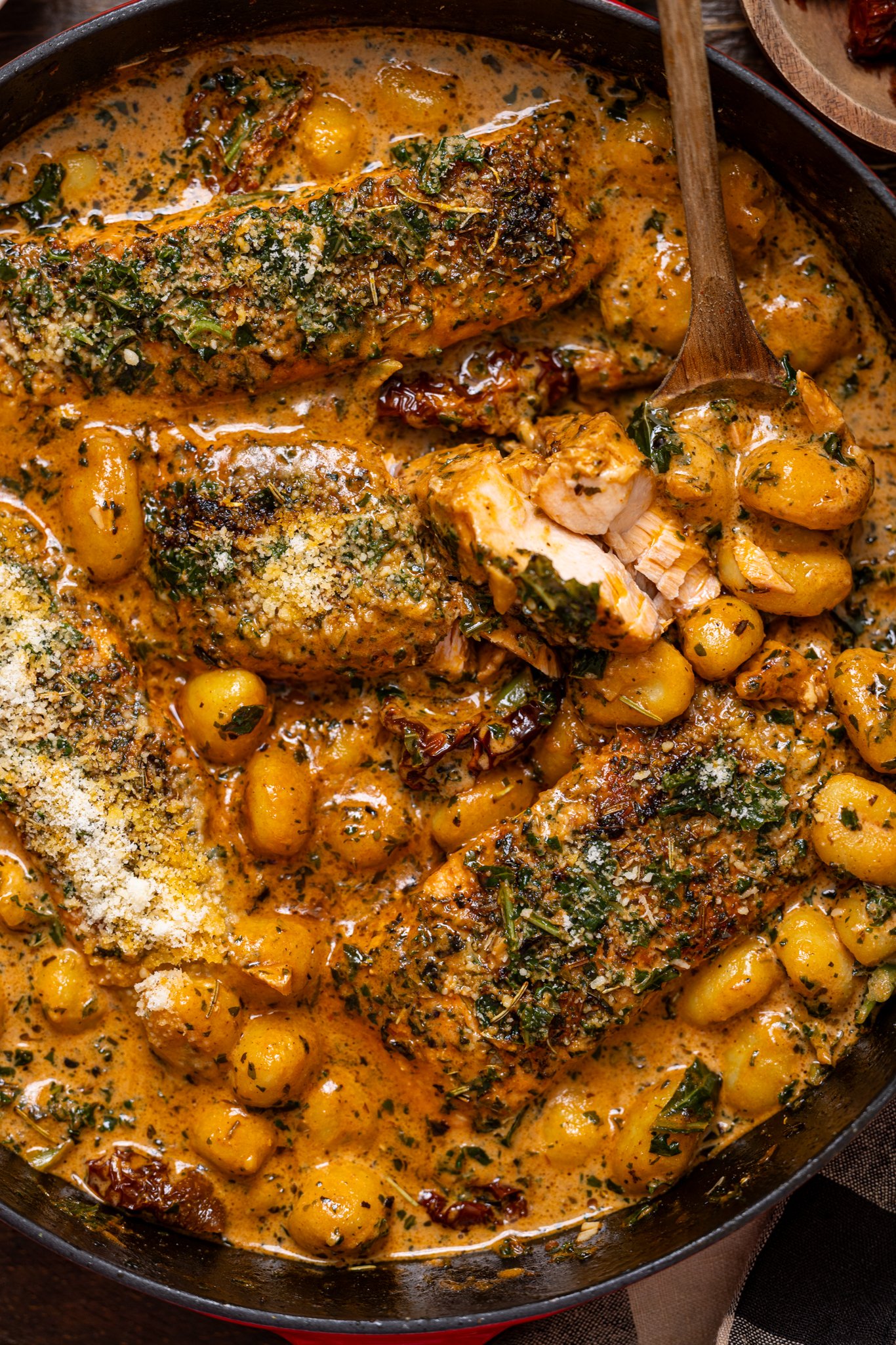 Up close shot of The Best Tuscan Marry Me Salmon with gnocchi in a skillet.