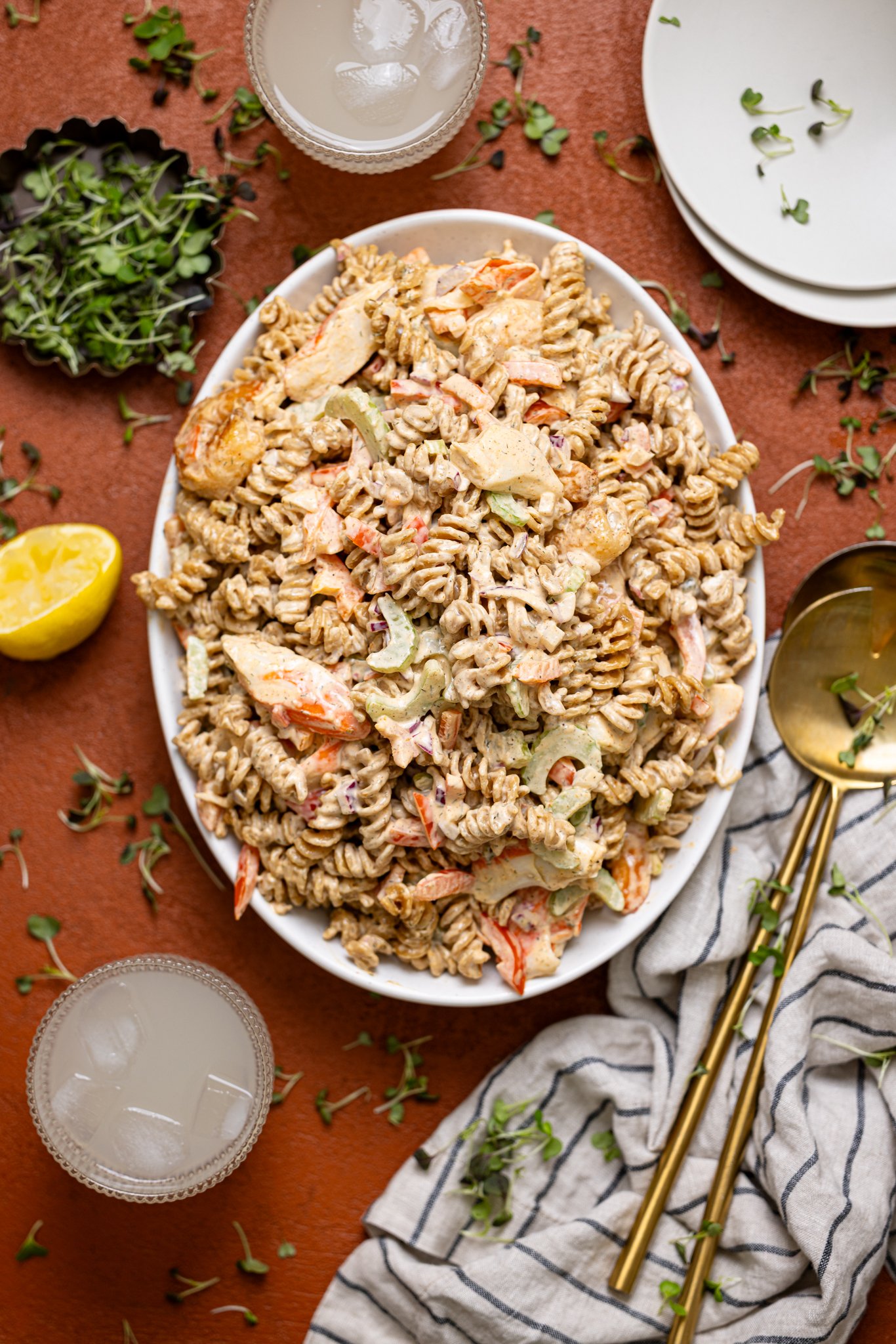 Best Seafood Salad Recipe on a platter with serving utensils and drinks.