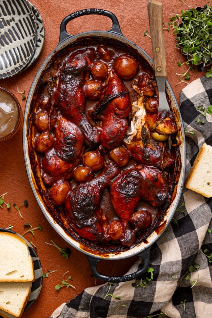 Jamaican Baked BBQ Jerk Chicken Legs in a baking dish with a fork.