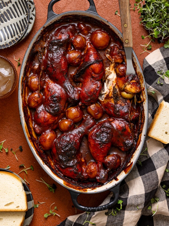 Jamaican Baked BBQ Jerk Chicken Legs in a baking dish with a fork.