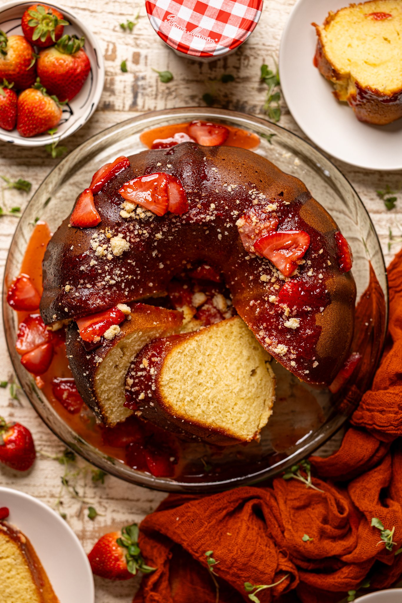 Strawberry Shortcake Bundt Cake with slices cut on a cake stand.