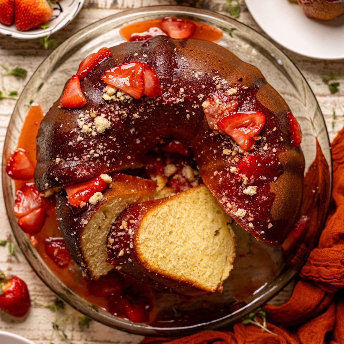 Strawberry Shortcake Bundt Cake with slices cut on a cake stand.