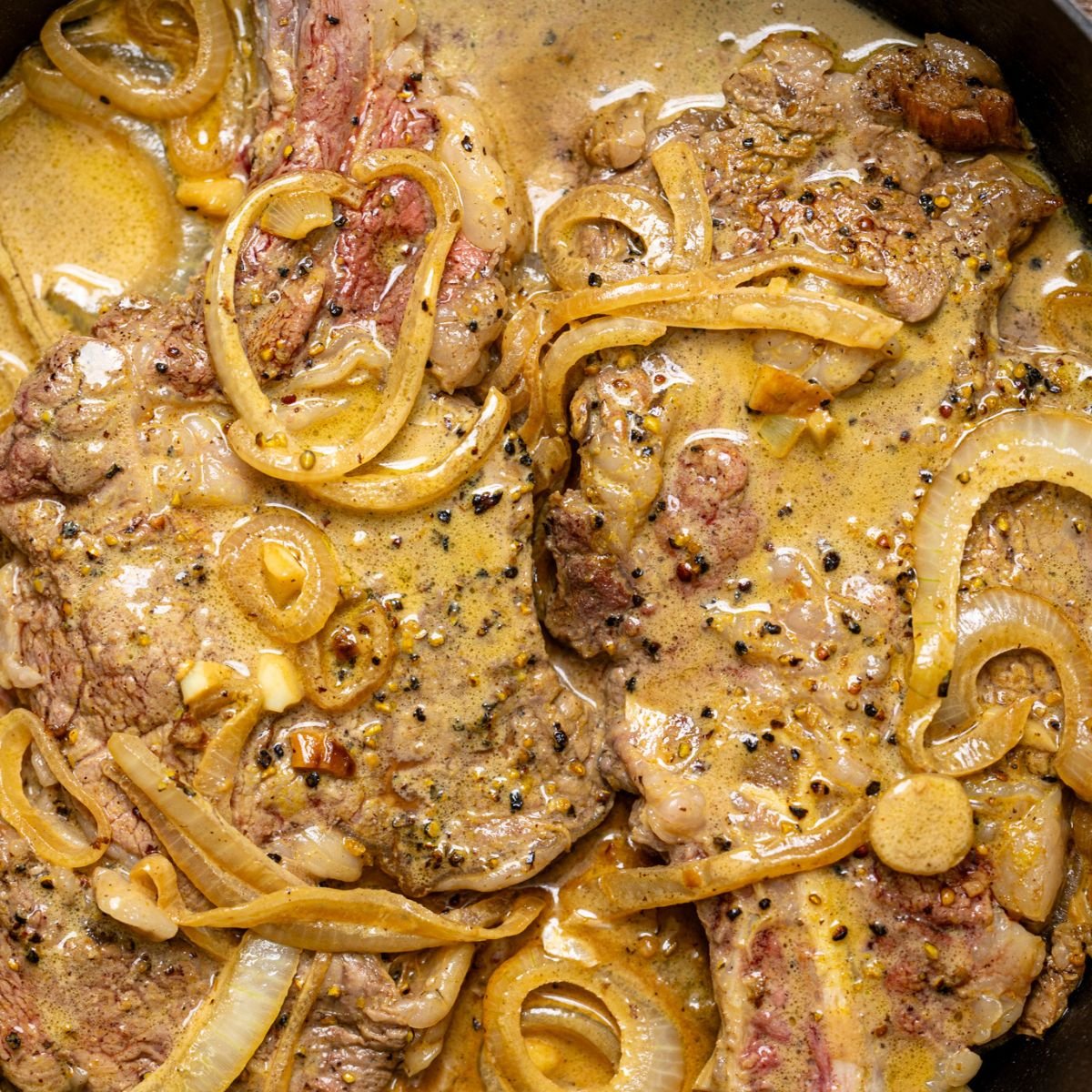 Up close shot of The Best Southern Smothered Steak in a skillet.