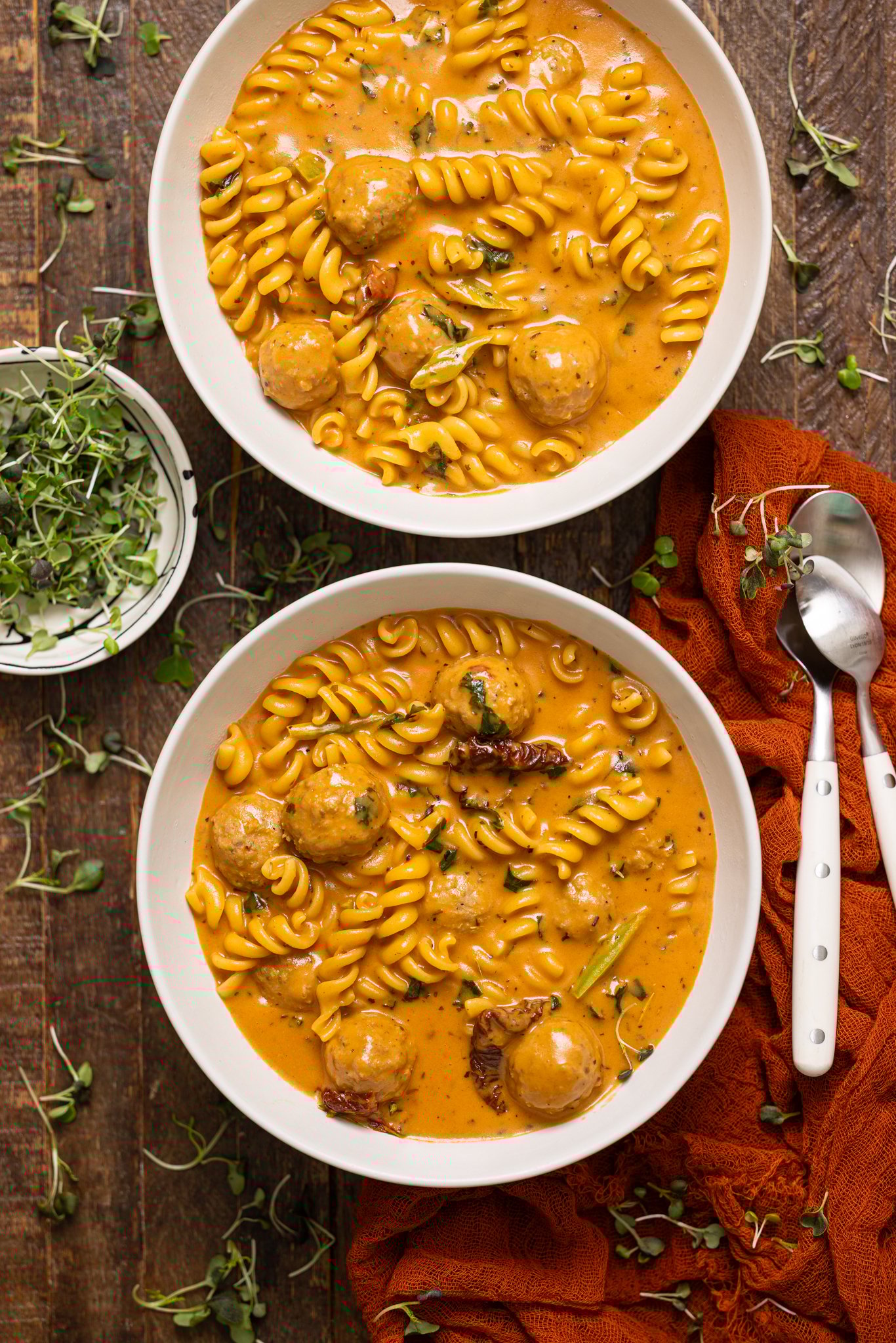 Image of two bowls of Hearty Tuscan 'Marry Me' Meatball Soup with spoons.