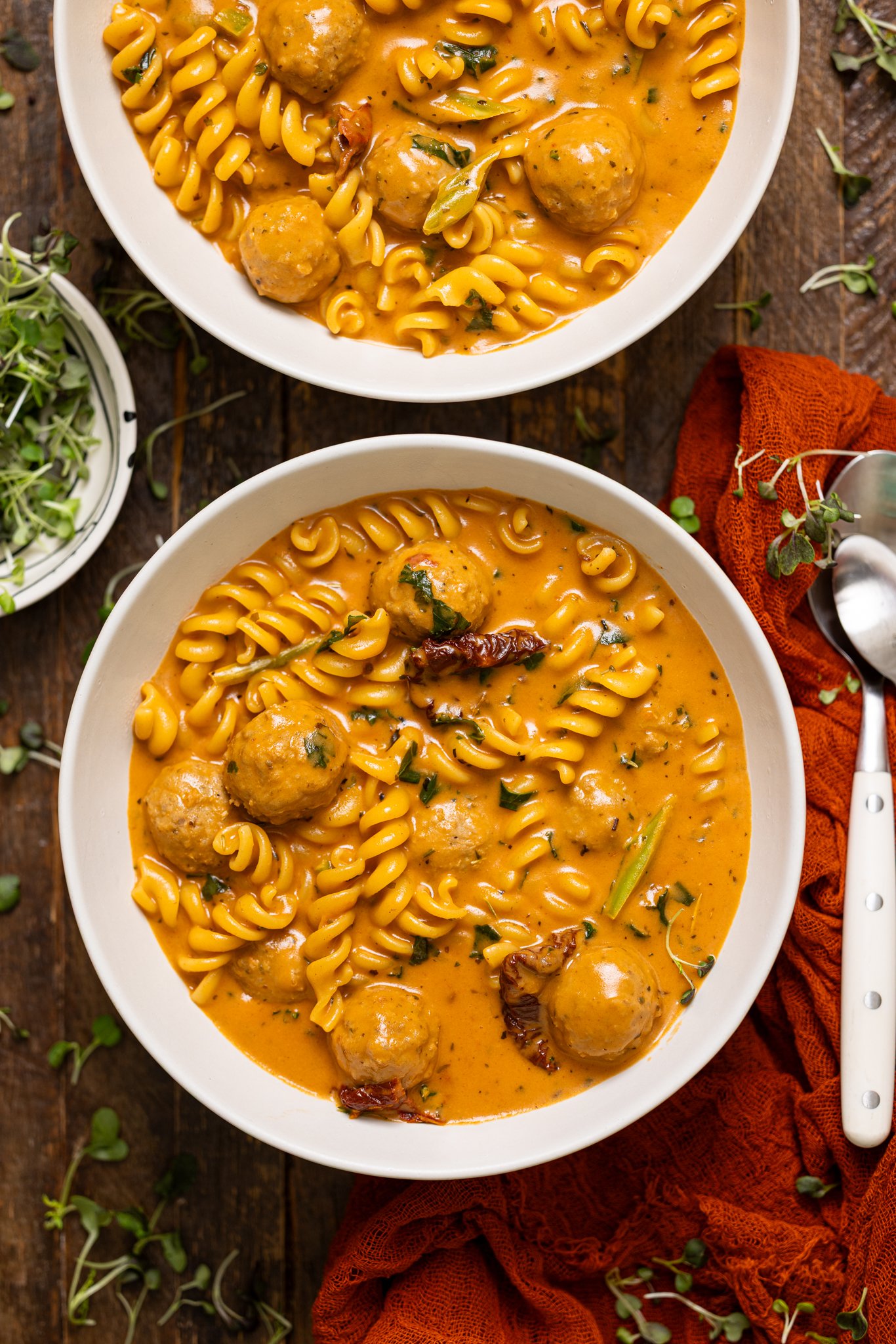 Two bowls of Hearty Tuscan 'Marry Me' Meatball Soup with spoons.