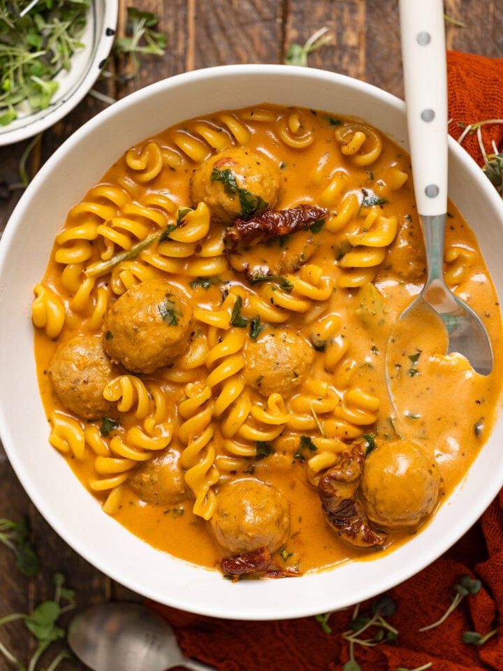 Up close shot of Hearty Tuscan 'Marry Me' Meatball Soup with spoons.