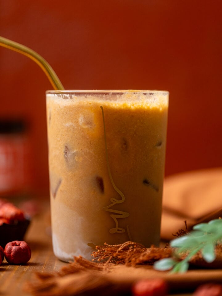 Up close shot of My Fave Pumpkin Dirty Chai Iced Latte in a glass with a straw.